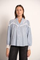 חולצה רפויה בצבע כחול עמוק, עם רקמה מורכבת על בד חלק, ככל הנראה כותנה, בגזרה רפויה.